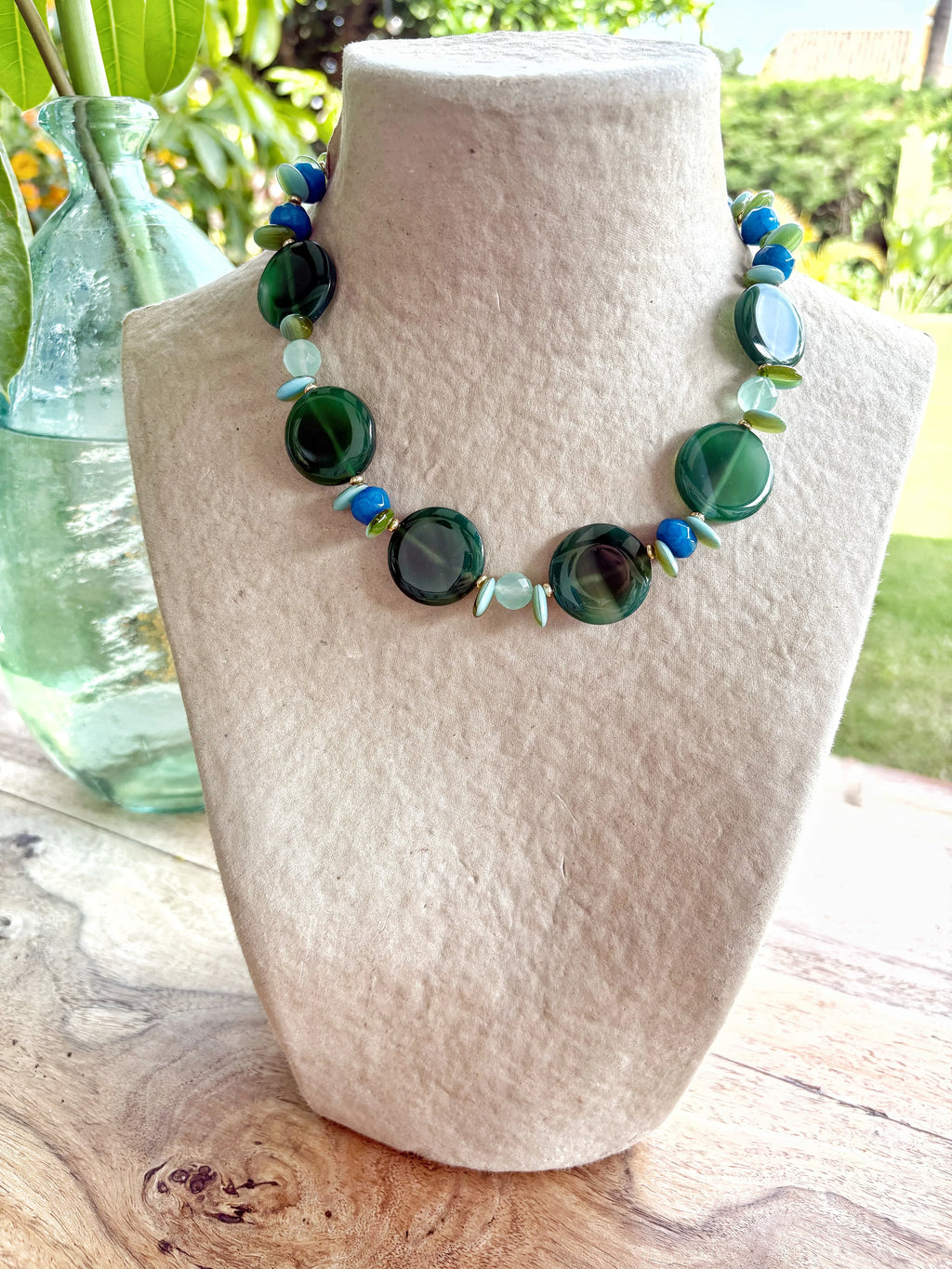 Collar corto artesanal de piedras semipreciosas verdes y azules con diseño irregular en exhibidor, Joyas La Selva.