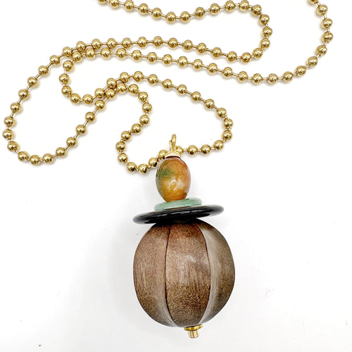 Detalle del colgante de madera tallada con ágata negra, jade verde y cuenta de jade miel del Collar Cacao – TideStone