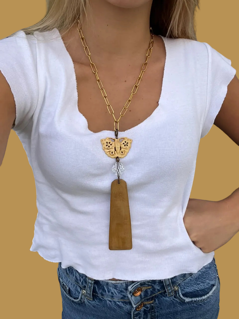 Collar Colgante Mariposa de hueso tallado y cristal puesto con camiseta blanca – TideStone